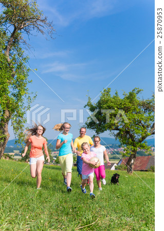 Father with children running on green meadow grass Father with children running on green meadow grass 25870953
