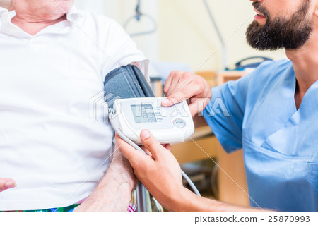 Nurse measuring blood pressure of senior patient 25870993