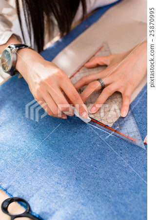 Detail of hands with scissors at tailor shop  25870995