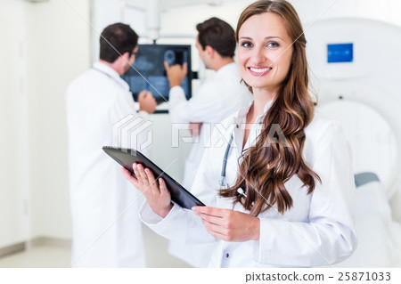 Doctor with colleagues standing in hospital at CT Doctor with colleagues standing in hospital at CT 25871033