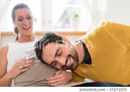 Dad listening at belly of his pregnant wife 25871035