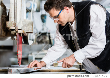 Handyman in stone carving factory at diamond saw Handyman in stone carving factory at diamond saw 25871427