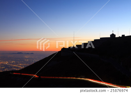 Light trails with building in silhouette. 25876974