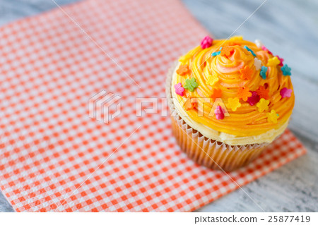Cupcake with orange icing. 25877419