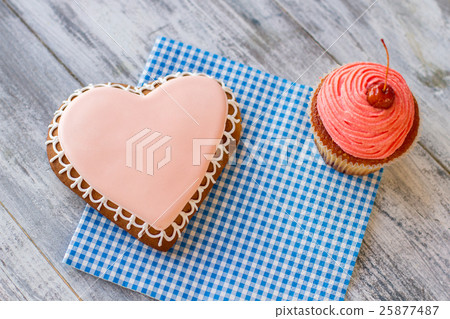 Heart cookie and pink cupcake. Heart cookie and pink cupcake. 25877487