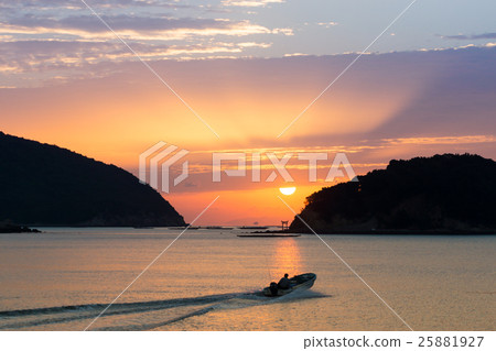 A ship sailing beside an island with torii and rising sunrise 25881927