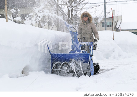 A woman snow removing 25884176