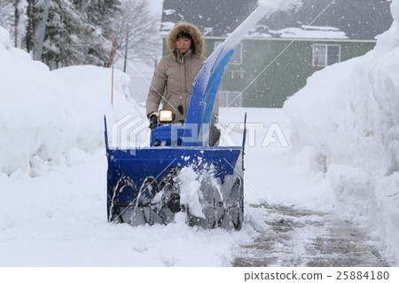 A woman snow removing A woman snow removing 25884180