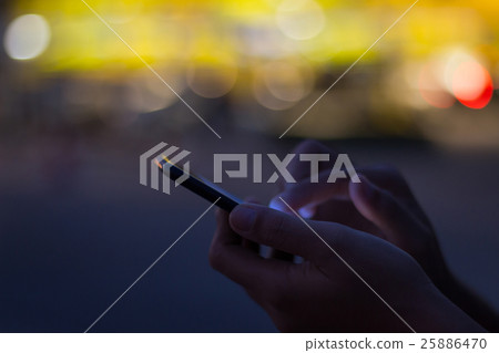 close-up hand use phone on night time in the city 25886470