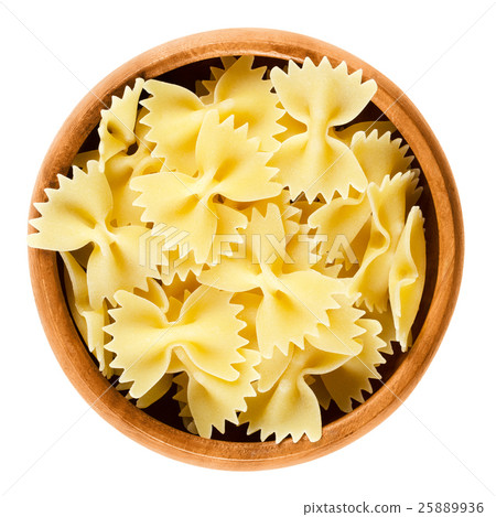 Farfalle pasta in wooden bowl over white 25889936
