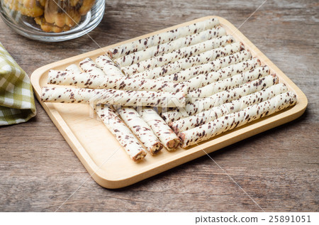 chocolate wafer sticks on plate with wooden table 25891051
