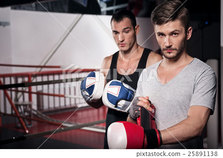 Two man wearing boxing gloves 25891138