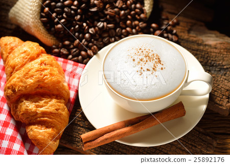 Coffee cup and coffee beans on wooden background Coffee cup and coffee beans on wooden background 25892176