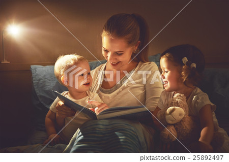 happy family mother and children read a book in bed 25892497