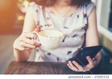 Close up of hand woman using phone in coffee shop 25895532