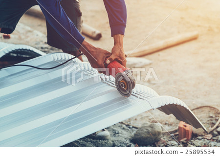 close up hand man use steel cutting to roof metal 25895534