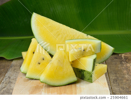 Yellow watermelon sliced on wooden background Yellow watermelon sliced on wooden background 25904661