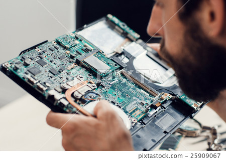 Engineer studying computer motherboard, close-up Engineer studying computer motherboard, close-up 25909067