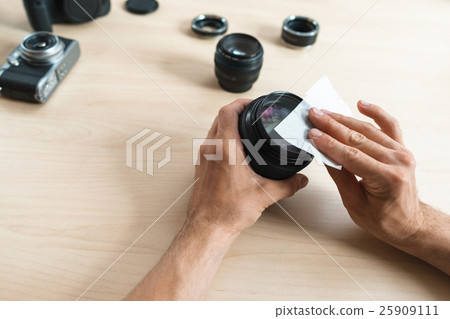Camera lens cleaning with wet wipe, close-up 25909111