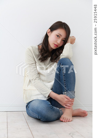A woman sitting with her knees up A woman sitting with her knees up 25915448