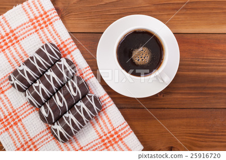 Coffee and cookies glazed on the tablecloth. 25916720