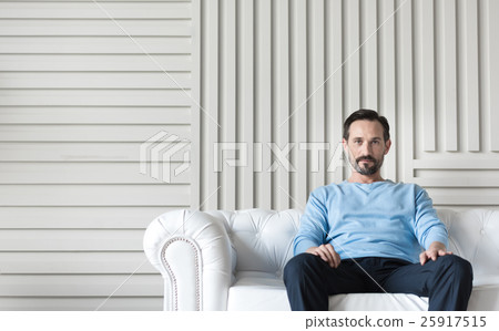 Handsome confident man sitting in the middle of Handsome confident man sitting in the middle of 25917515