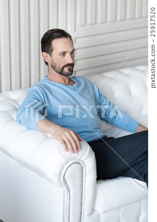 Serious handsome man sitting confidently on the 25917520