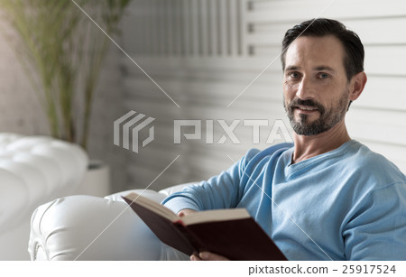 Nice delighted man reading a story Nice delighted man reading a story 25917524