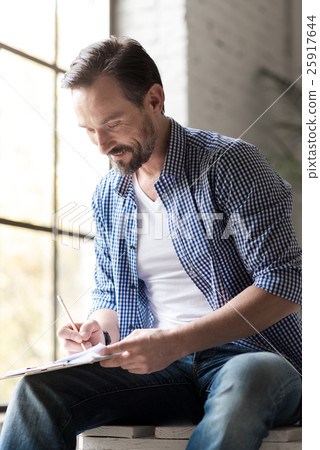 Happy delighted man writing with a pencil 25917644