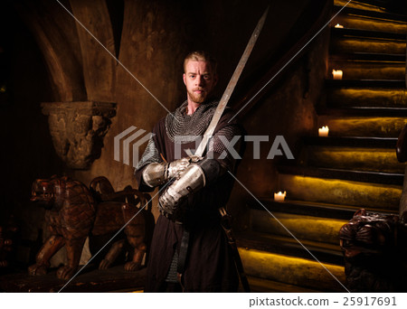 Medieval knight in ancient castle interior. 25917691