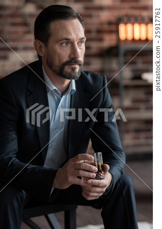 Thoughtful successful businessman holding a glass 25917761