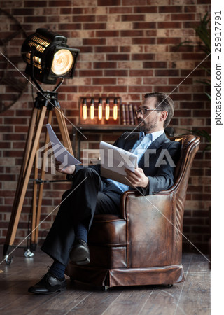 Good looking serious man sitting in the armchair 25917791