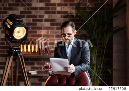 Serious stylish man reading reviewing some 25917806