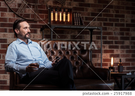 Optimistic attractive businessman relaxing after a 25917988