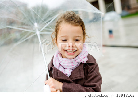 Little girl under the transparent umbrella outside Little girl under the transparent umbrella outside 25918162