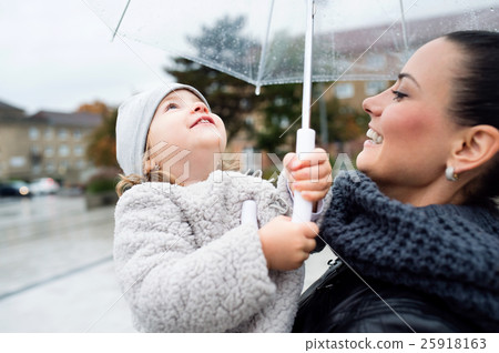 Beautiful mother holding her little daughter under 25918163