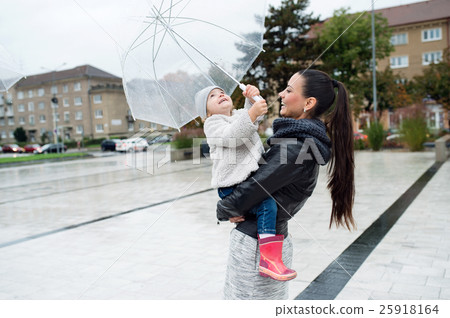 Beautiful mother holding her little daughter under 25918164