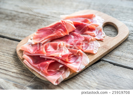 Slices of jamon on the wooden board Slices of jamon on the wooden board 25919708