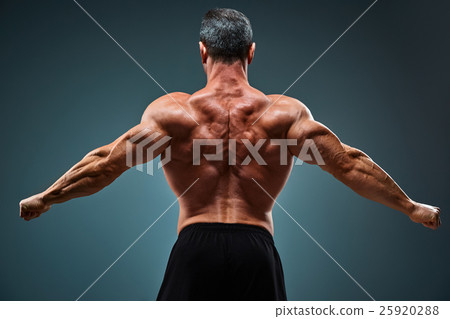 Stock Photo: torso of attractive male body builder on gray