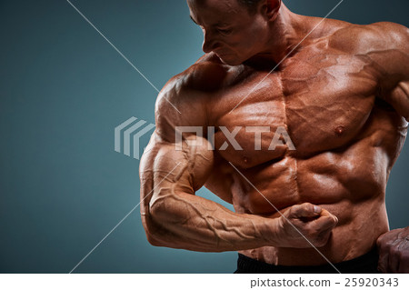 torso of attractive male body builder on gray 25920343
