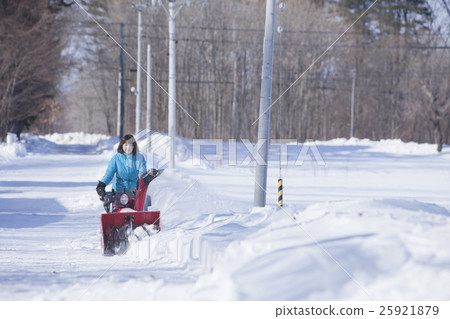 A woman snow removing A woman snow removing 25921879