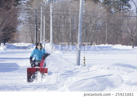A woman snow removing A woman snow removing 25921881