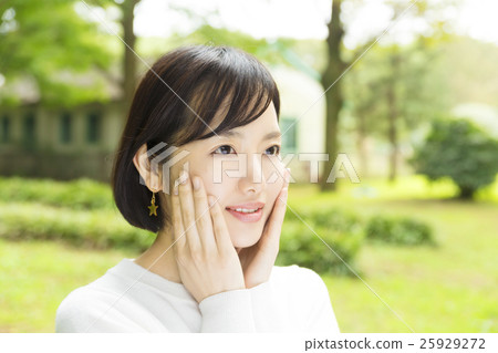 Beauty & Emotions Combined female outdoor park I feel nice and happy on my cheeks with both hands 25929272