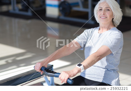 Laughing beautiful woman using rowing machine. Laughing beautiful woman using rowing machine. 25932221