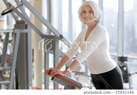 Cheerful fit senior woman using gym equipment. 25932348