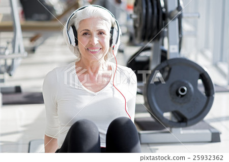 Pleased senior woman listening to music after 25932362