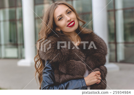 Pretty woman is wearing luxury dark fur coat 25934984