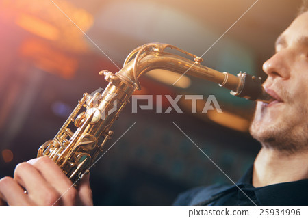 Young man in suit playing on saxophone Young man in suit playing on saxophone 25934996