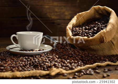 Coffee cup with smoke and coffee beans on old wood Coffee cup with smoke and coffee beans on old wood 25941302