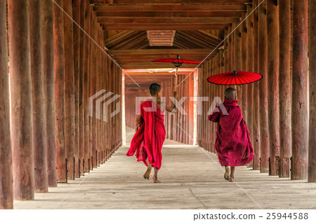 Back side of two young monk holding the traditional umbrella on the Mya Thein Tan Pagoda at bagan, mandalay, myanmar Buddhist novice are walking in pagoda,myanmar 25944588